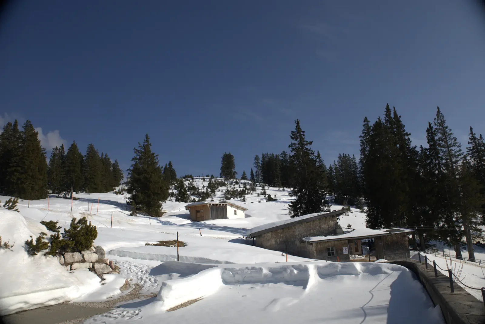 Verschneite Landschaft mit Häusern und Nadelbäumen